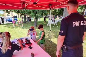 Policjant obserwuje bawiące się dzieci podczas pikniku