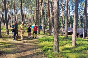 Kontrolujący obozy mundurowi idą w kierunku namiotów