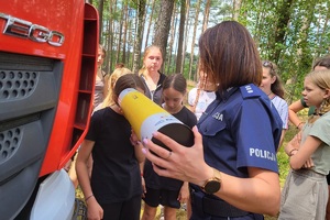 Policjantka pokazuje dziecku działanie magicznej tuby