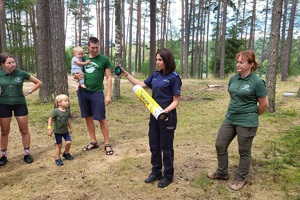 Mundurowi stoją przed grupą harcerzy, rozmawiają z dziećmi