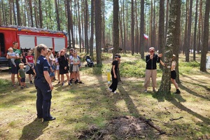 Młodzież pokonuje slalom między drzewami z ubranymi alkogoglami