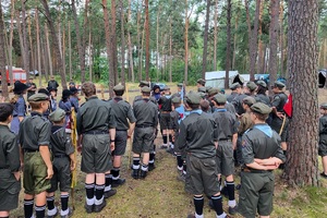 Harcerze stoją w rzędach, słuchają policjantki