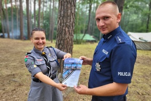 Policjant trzyma wspólnie z harcerką plakat promujący konkurs