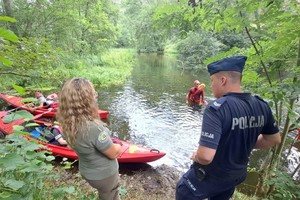 Policjant sprawdza pływających na kajakach