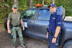 Strażnik Leśny wraz z Policjantem stoją przy pojeździe Straży Leśnej