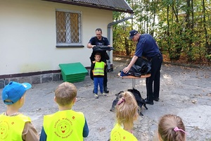 Policjanci ubierają kamizelkę chłopcu