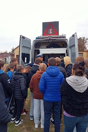 Policjant pokazuje uczniom wyposażenie radiowozu