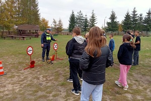 Policjanci pokazują znaki wykorzystywane podczas zdarzeń drogowych