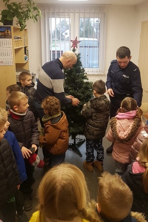 Policjanci zawieszają ozdoby na choince