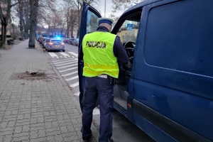 Policjant kontroluje pojazd stojący przy przejściu