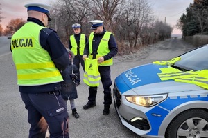 Mundurowi rozmawiają z dzieckiem i wręczają mu kamizekę