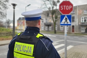 Policjant stoi przy znaku STOP