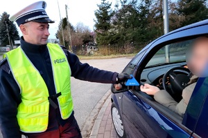 Policjanci ruchu drogowego podczas akcji rozdają kierowcom skrobaczki do szyb