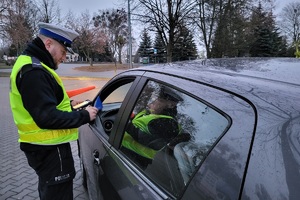 Policjanci ruchu drogowego podczas akcji rozdają kierowcom skrobaczki do szyb