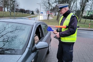 Policjanci ruchu drogowego podczas akcji rozdają kierowcom skrobaczki do szyb