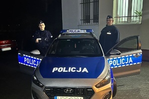 Policjanci stojący przy radiowozie