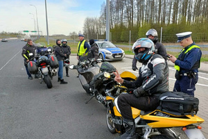 Policjant ruchu drogowego kontroluje grupę motocyklistów