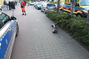 Miejsce wypadku drogowego z udziałem hulajnogi elektrycznej i pracujący przy zdarzeniu policjanci