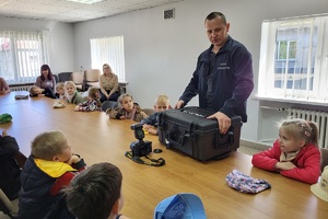 Policjanci goszczą na terenie komendy przedszkolaków, którym pokazują miejsce swojej codziennej służby