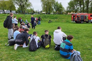 Policjanci podczas pikniku charytatywnego prowadzą pokaz posłuszeństwa psa i prezentują sprzęt służbowy