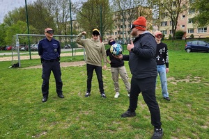 Policjanci podczas pikniku charytatywnego prowadzą pokaz posłuszeństwa psa i prezentują sprzęt służbowy