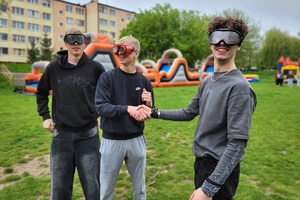 Policjanci podczas pikniku charytatywnego prowadzą pokaz posłuszeństwa psa i prezentują sprzęt służbowy