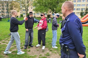 Policjanci podczas pikniku charytatywnego prowadzą pokaz posłuszeństwa psa i prezentują sprzęt służbowy