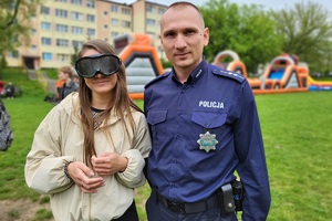 Policjanci podczas pikniku charytatywnego prowadzą pokaz posłuszeństwa psa i prezentują sprzęt służbowy