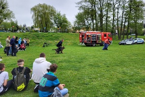 Policjanci podczas pikniku charytatywnego prowadzą pokaz posłuszeństwa psa i prezentują sprzęt służbowy