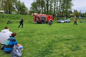 Policjanci podczas pikniku charytatywnego prowadzą pokaz posłuszeństwa psa i prezentują sprzęt służbowy
