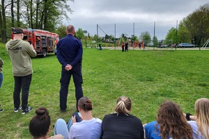 Policjanci podczas pikniku charytatywnego prowadzą pokaz posłuszeństwa psa i prezentują sprzęt służbowy