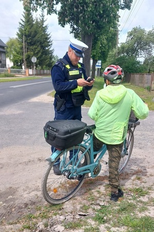 Policjant kontroluje rowerzystę