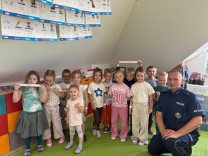 Policjanci prowadzą spotkanie i rozmawiają z przedszkolakami o bezpieczeństwie na drodze
