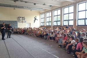 Policjanci prowadzący zajęcia z uczniami na temat bezpieczeństwa na drodze