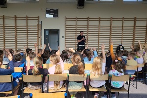 Policjanci prowadzący zajęcia z uczniami na temat bezpieczeństwa na drodze