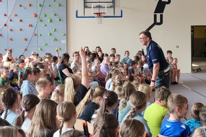 Policjanci prowadzący zajęcia z uczniami na temat bezpieczeństwa na drodze