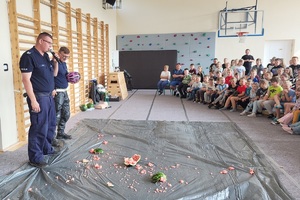 Policjanci prowadzący zajęcia z uczniami na temat bezpieczeństwa na drodze