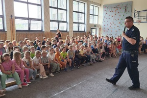 Policjanci prowadzący zajęcia z uczniami na temat bezpieczeństwa na drodze
