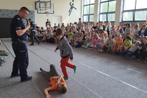 Policjanci prowadzący zajęcia z uczniami na temat bezpieczeństwa na drodze