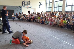 Policjanci prowadzący zajęcia z uczniami na temat bezpieczeństwa na drodze