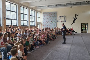 Policjanci prowadzący zajęcia z uczniami na temat bezpieczeństwa na drodze