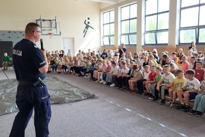 Policjanci prowadzący zajęcia z uczniami na temat bezpieczeństwa na drodze