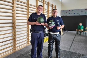 Policjanci prowadzący zajęcia z uczniami na temat bezpieczeństwa na drodze