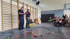 Policjanci prowadzący zajęcia z uczniami na temat bezpieczeństwa na drodze