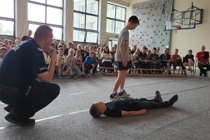 Mundurowi prowadzą pogadankę na temat poruszania się hulajnogami po drodze i używania kasków