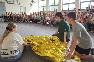 Mundurowi prowadzą pogadankę na temat poruszania się hulajnogami po drodze i używania kasków