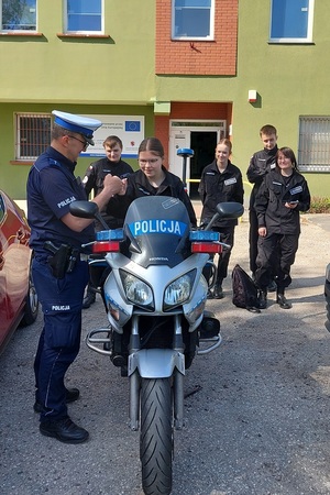 Policjanci podczas spotkania z uczniami szkoły średniej rozmawiają o pracy w mundurze