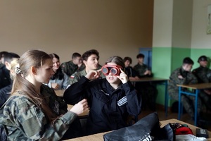 Policjanci podczas spotkania z uczniami szkoły średniej rozmawiają o pracy w mundurze