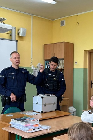 Policjanci podczas pogadanki prezentują walizkę edukacyjną