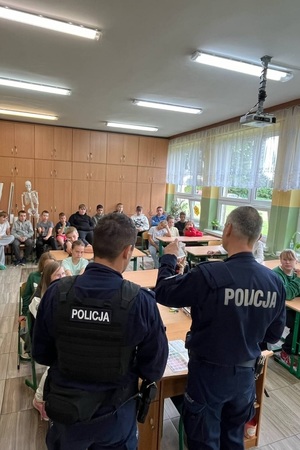 Policjanci podczas pogadanki prezentują walizkę edukacyjną